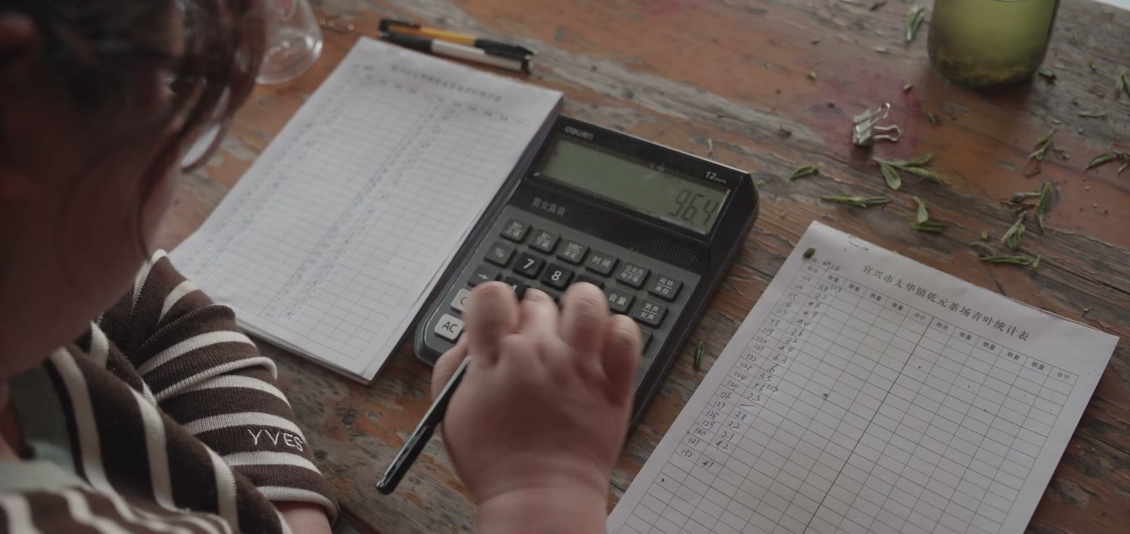 A calculator and a ledger on a table at the collection point